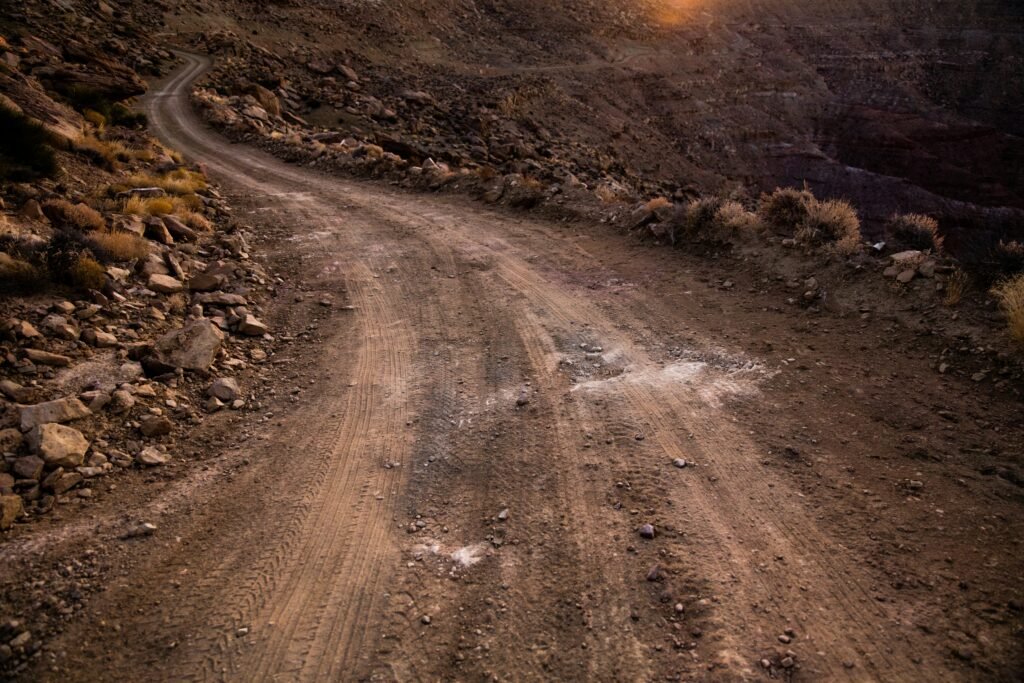 Camino de tierra que serpentea entre montañas áridas